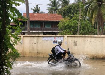 ទិដ្ឋភាពពលរដ្ឋជិះម៉ូតូកាត់ទឹកលើកំណាត់ផ្លូវ៦៩បេតេ(69BT) ក្នុងសង្កាត់បឹងទំពន់២ ខណ្ឌមានជ័យ រាជធានីភ្នំពេញកាលពីថ្ងៃទី៧ ខែកក្កដា ឆ្នាំ២០២៣។ (លោក សុត បាន)