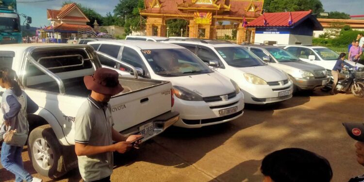 ទិដ្ឋភាពរថយន្តឈ្នួលជាច្រើនប្រមូលផ្តុំគ្នាតវ៉ានៅច្រកអន្តរជាតិអូរស្មាច់ ស្ថិតក្នុងសង្កាត់អូរស្មាច់ ក្រុងសំរោង ខេត្តឧត្តរមានជ័យ បង្កការកកស្ទះជាង២០នាទីនៅថ្ងៃទី៥ ខែឧសភា ឆ្នាំ២០២៣នេះ។ (ចៀវ ពន្លឺ)