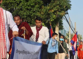 លោក កើត សារ៉ាយ (បង់កក្រមាក្រហម) កាន់បដានៅកណ្តាលកំពុងដើរធម្មយាត្រាក្នុងរាជធានីភ្នំពេញផ្សាយមេត្តាចិត្តផ្សារភ្ជាប់នឹងសិទ្ធិមនុស្ស ក្រោមប្រធានបទ ធានាសេចក្តីថ្លៃថ្នូរ សេរីភាព និងយុត្តិធម៌ដល់ពលរដ្ឋគ្រប់រូប កាលពីថ្ងៃទី១០ ខែធ្នូ ឆ្នាំ២០២៣។ (រូបភាព៖ ផ្តល់ឱ្យ)