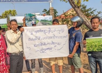 ជនជាតិដើមភាគតិចកួយប្រមាណ៣០នាក់បានទៅប្រមូលផ្តុំមុខសាលាស្រុកត្បែងមានជ័យ កាលពីថ្ងៃទី២៩ ខែកុម្ភៈ ឆ្នាំ២០២៤ ដោយពួកគេបានឈរលើកបដា និងសសេរថា «មន្ត្រីគប់គិតគ្នាធ្វើប្លង់កម្មសិទ្ធិជាន់លើដីរបស់សហគមន៍ជនជាតិដើមភាគតិចកួយនៅឃុំប្រមេរុ»។ (ផ្តល់ឱ្យ)