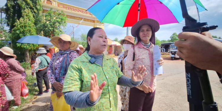 អ្នកស្រី ផាវ ញ៉ើង (ស្រីពាក់មូក ក្រោមឆ័ត្រ) និងសហគមន៍មានវិវាទដីធ្លីនៅខេត្តកោះកុងផ្សេងទៀត ថតនៅមុខអយ្យការអមសាលាដំបូងខេត្តកោះកុង នៅឆ្នាំ២០២៤។ (ផ្តល់ឱ្យ)