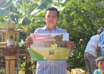 កសិករមួយរូប ដែលជាសមាជិកសហគមន៍មានជ័យ ស្ថិតក្នុងឃុំធ្មា ស្រុករំដួល ខេត្តស្វាយរៀង កាន់បដា ចូលរួមយុទ្ធនាការ «និយាយថាទេ ថ្នាំពុល និងជីគីមីប៉ះពាល់សុខភាព»កាលពីថ្ងៃទី ២៣ ខែមេសា ឆ្នាំ២០២៥ ។ (ហ្វេសប៊ុក សមាគមសម្ព័ន្ធសហគមន៍កសិករកម្ពុជា CCFC Cambodia)