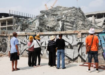 ទិដ្ឋភាពពលករខ្មែរនាំគ្នាឈររង់ចាំព័ត៌មានអំពីសាច់ញាតិដែលជាប់នៅក្នុងគំនរអគារដែលដួលរលំនៅទីក្រុងបាងកក ប្រទេសថៃ ដោយគ្រោះរញ្ជួយដីកាលពីថ្ងៃទី២៩ ខែមីនា ឆ្នាំ២០២៥។ (REUTERS/Chalinee Thirasupa )