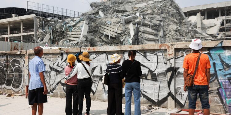 ទិដ្ឋភាពពលករខ្មែរនាំគ្នាឈររង់ចាំព័ត៌មានអំពីសាច់ញាតិដែលជាប់នៅក្នុងគំនរអគារដែលដួលរលំនៅទីក្រុងបាងកក ប្រទេសថៃ ដោយគ្រោះរញ្ជួយដីកាលពីថ្ងៃទី២៩ ខែមីនា ឆ្នាំ២០២៥។ (REUTERS/Chalinee Thirasupa )